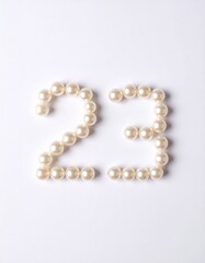 Obraz premium Number 23 made out of small pearls on a neutral solid background