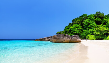 Naklejka premium Beautiful tropical beach with white sand, turquoise sea, coastal rocks, and lush green vegetation on the Similan Islands, near Phuket in Thailand.