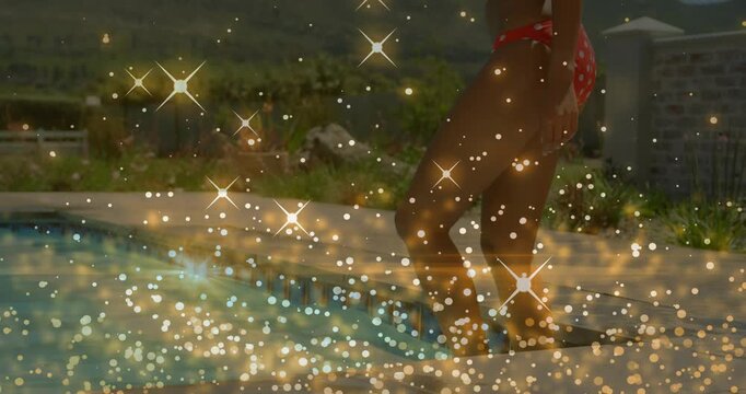 Adult woman lifting leg, stepping into pool to swim, swimsuit, gold sparkles obscuring legs leisure