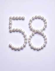Obraz premium Number 58 made out of small pearls on a neutral solid background