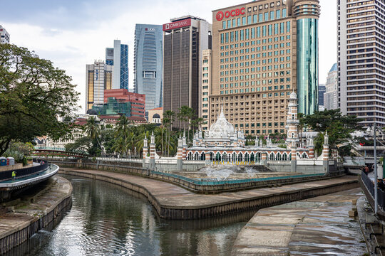 Historic Masjid Jamek at the confluence of the Klang and Gombak rivers, framed by modern skyscrapers and the "River of Life" project. Preserving sacred spaces within a dense metropolis. 