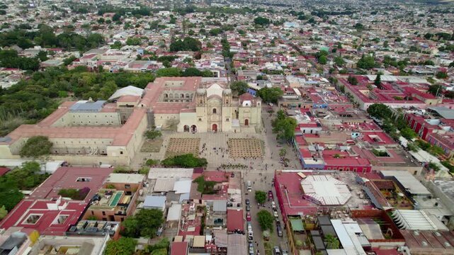 Vuelo de drone en Templo de Santo Domingo de Guzm&aacute;n, Oaxaca: Movimiento Dolly In lateral destacando la fachada de cantera verde, torres barrocas y plaza principal en M&eacute;xico.