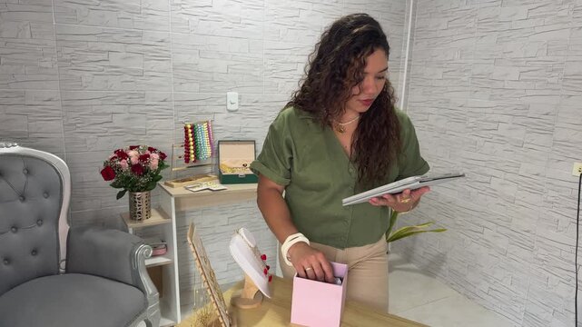 Female entrepreneur managing her handmade jewelry business online from her home office workshop