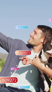 Vertical video: Man holding dog, raising arm taking selfie, social badges 609272 floating in front