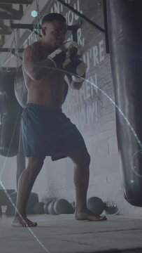 Vertical video: Boxer raising knee, landing kick, hitting bag in boxing drill while flares overlay