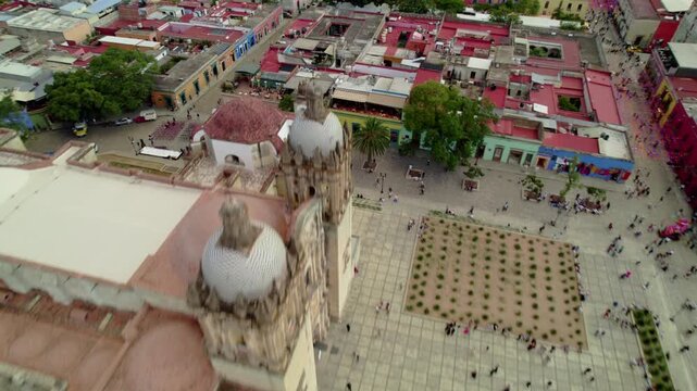 Vuelo de drone en Templo de Santo Domingo de Guzm&aacute;n, Oaxaca: Movimiento Dolly In lateral destacando la fachada de cantera verde, torres barrocas y plaza principal en M&eacute;xico.
