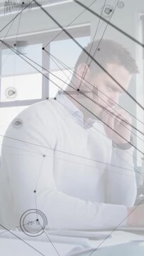 Vertical video: Man reading finance papers, checking phone, causing transparent HUD linking files