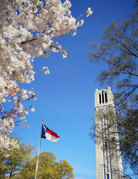 The Memorial Bell Tower and the state flag of North Carolina on the campus of North Carolina State University in Raleigh in Spring