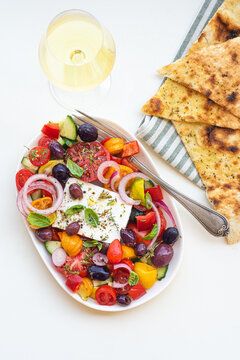 Greek salad with feta cheese and herbs with wine Resina. Greek bowl. Mediterranean cuisine and Greece. Healthy eating and recipes 