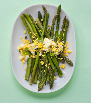 Asparagus salad Mimosa. Spring and Easter salad with grated egg, capers and aromatic dressing. Sunlight background. Healthy vegetarian balanced recipes for spring, seasonal cuisine 