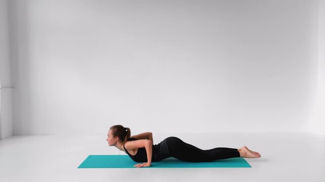 Flexible woman performing upward-facing dog and cobra yoga poses for backbend strength isolated on a white background