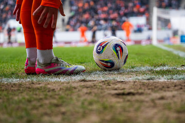 Fototapeta premium Football match between KGHM Zaglebie Lubin vs Lech Poznan. Detail of player's legs and the ball in the corner.