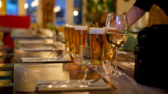 The waiter puts beer and wine on the table