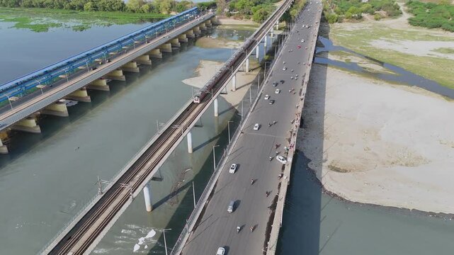 Aerial 4k view of Metro train Running on the Yamuna River at Kalandi Kunj, Delhi, India