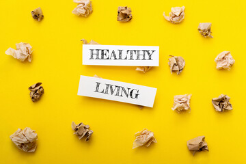 Healthy living concept with crumpled paper surrounding bold text on vibrant yellow background, symbolizing wellness and lifestyle choices for improved health and vitality