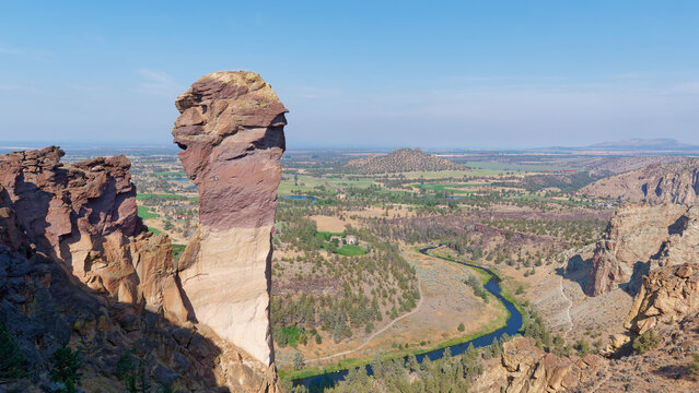 Deep river canyon view with a hiking trail alongside massive vertical rock walls at Smith Rock State Park, Oregon, USA