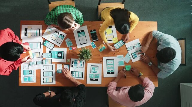 Creative team sitting and discussing while brainstorm about Ux Ui design mobile phone interface. People planning strategy start up project while planning a strategy at business meeting. Convocation.
