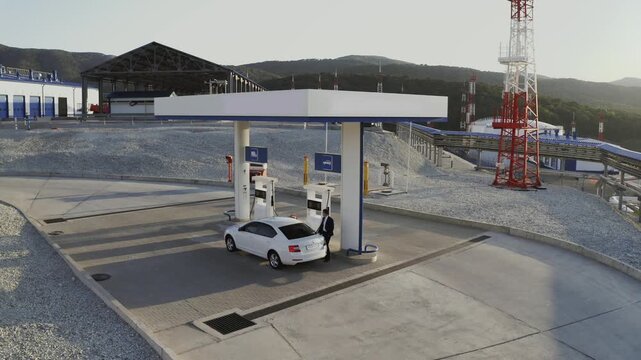 Refueling a hybrid vehicle at an electric charging station. Drone 