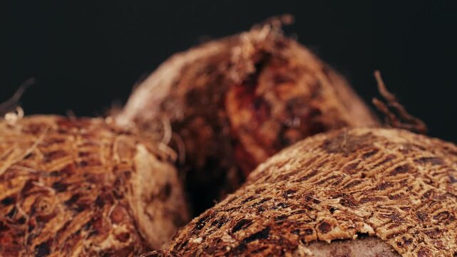 Taro vegetable tubers, Stack of raw, unpeeled tropical taro, Colocasia esculenta, on a market stall