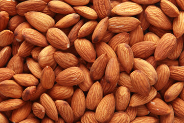 Fototapeta premium Peeled almond kernels. Close-up. The texture of the nut. A large number of peeled almonds. A vegan dish. View from above. Healthy eating. An energy product. Top view.