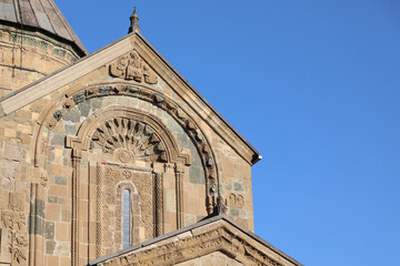 Obraz premium Ananuri fortress complex in georgia, close up of carved stone facade and church architecture, medieval ornamentation and reliefs under clear blue sky, historic religious landmark