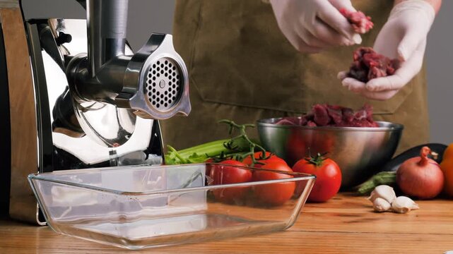 Meat grinder making chicken turkey burger, grinds the meat into minced meat. Minced pork, beef, protein food preparation.