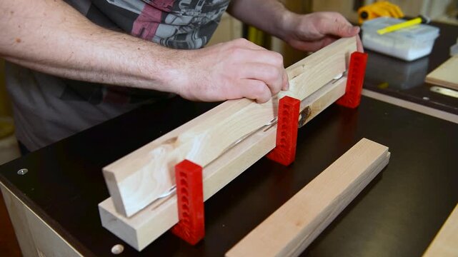 Skilled focused craftsman hands assembling clamps, securing bonding wooden boards. Precise woodworking, hands on expertise on mechanical setup, joinery artisan workspace, professional technique.