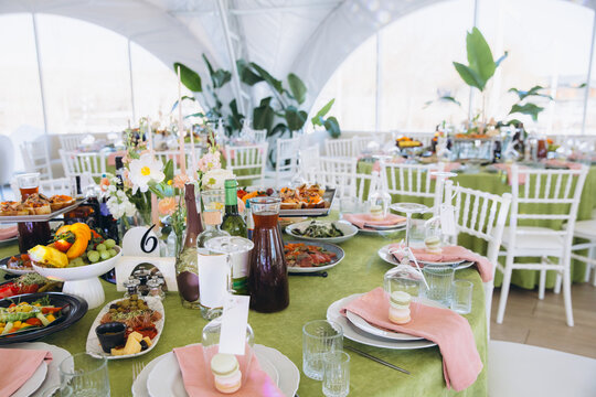 Wedding banquet table setting with delicious food and elegant decor in a luxurious event tent