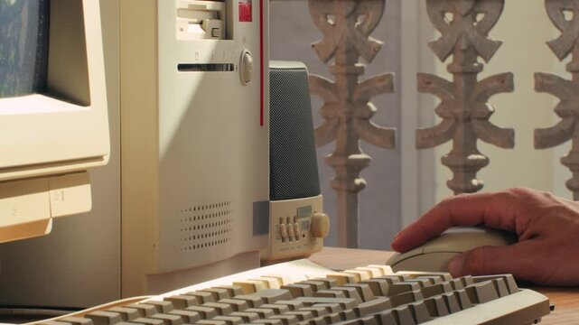 Man working and gaming on retro computer PC, IT engineer with vintage computer at home, using old fashion technology, close up of retro setup. 