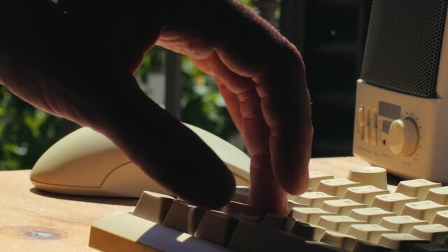 Man working and gaming on retro computer PC, IT engineer with vintage computer at home, using old fashion technology, close up of retro setup. 