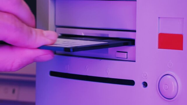 Floppy disc FDD close up, Using diskette for old PC computer macro. Archive programme or Music recorder, playing retro computer games. Vintage device for office, obsolete technology. 