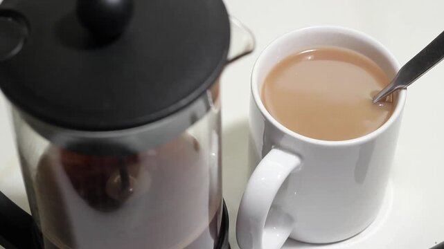 Fresh coffee with cream or milk. Mug in focus. HD video.