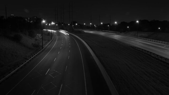Don Valley Parkway time lapse at night, Toronto. Corner with streaking lights. Black & white. HD.