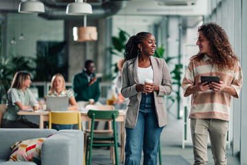 Diverse colleagues walking talking in modern office