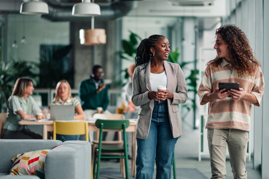 Diverse colleagues walking talking in modern office