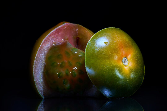 Still life of choco tomato sliced open with visible inner texture on black background