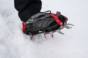 Naklejka premium Close-up of a mountain boot with strap-on crampons.