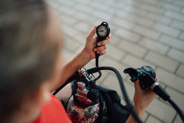Diver checking pressure gauge on oxygen tank, preparing scuba diving equipment for underwater adventure