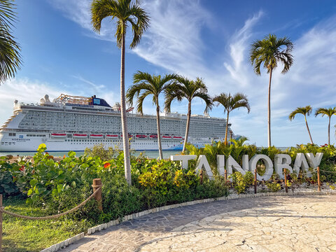 Puerto Plata, Dominican Republic - 15 January 2026: Sign on the waterfront of Taino Bay with the NCL Norwegian Breakaway cruise ship moored in the background