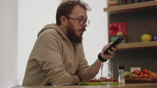 Casual Bearded Man Relaxing and Browsing on His Smartphone at Home