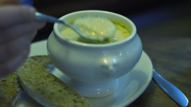 Bowl of creamy soup chowder with brown bread close up