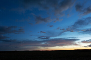 Obraz premium Natural beautiful clouds at dawn. Dramatic colorful red-orange to dark gray sky with clouds at sunset or dawn.