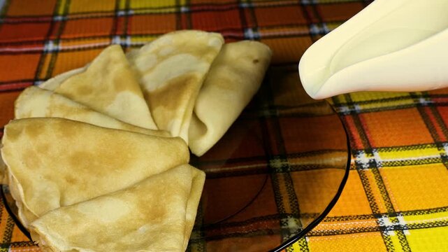 Pancakes in a bowl with condensed milk. 4K video.