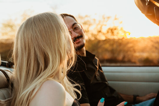 Boyfriend looking at girlfriend in convertible car
