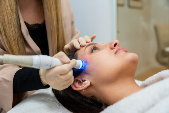 Woman receiving advanced facial skincare treatment at aesthetic clinic