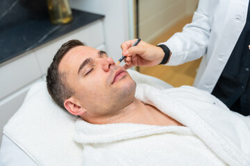 Fototapeta premium Man receiving cosmetic skin treatment at aesthetic clinic