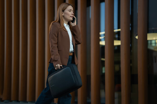 Businesswoman walking and talking on mobile phone