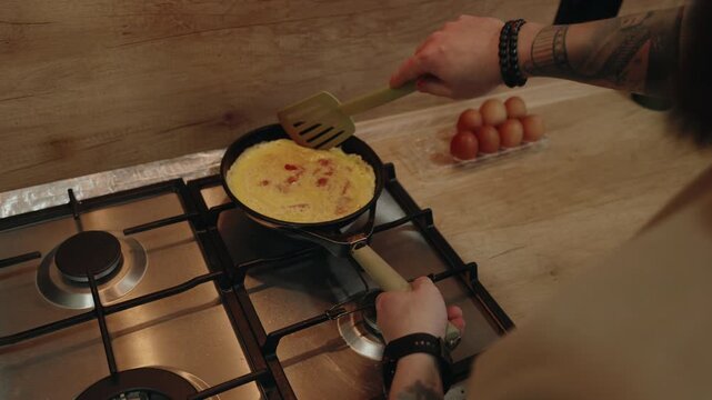Cooking a Delicious Omelet with Tomatoes for a Healthy Breakfast in a Modern Kitchen