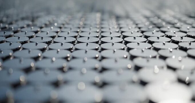 Rows of reflective silver metallic discs with central points