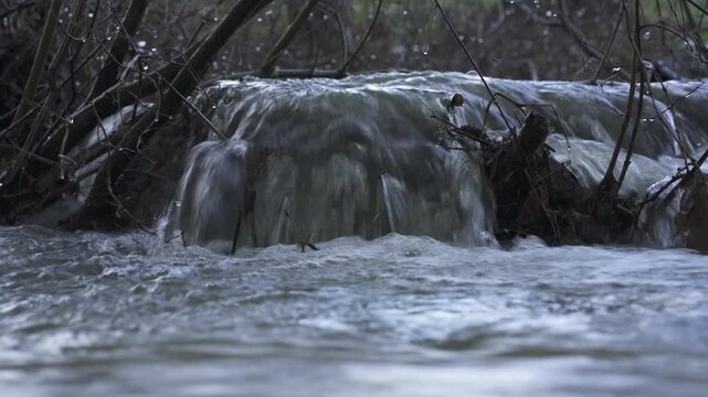 Flooded river with strong current and overflow, high water level in natural landscape &ndash; extreme weather footage